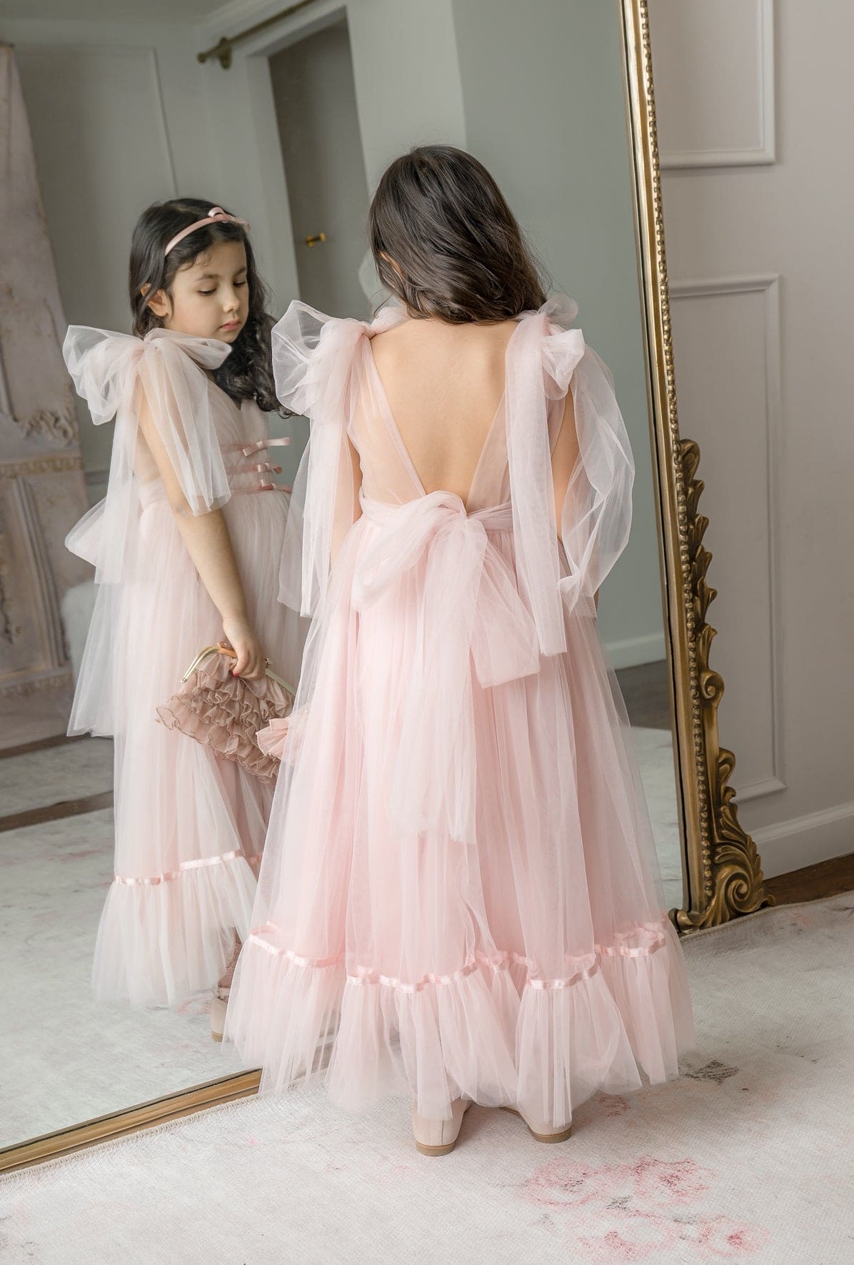 Back view of Camila Light Pink Tulle Gown featuring deep V-back design and oversized satin bow with flowing tulle skirt.