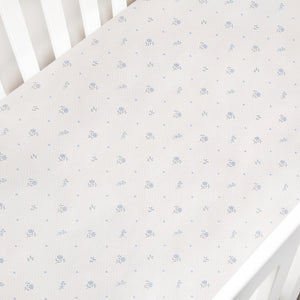 Floral patterned crib sheet on a white crib