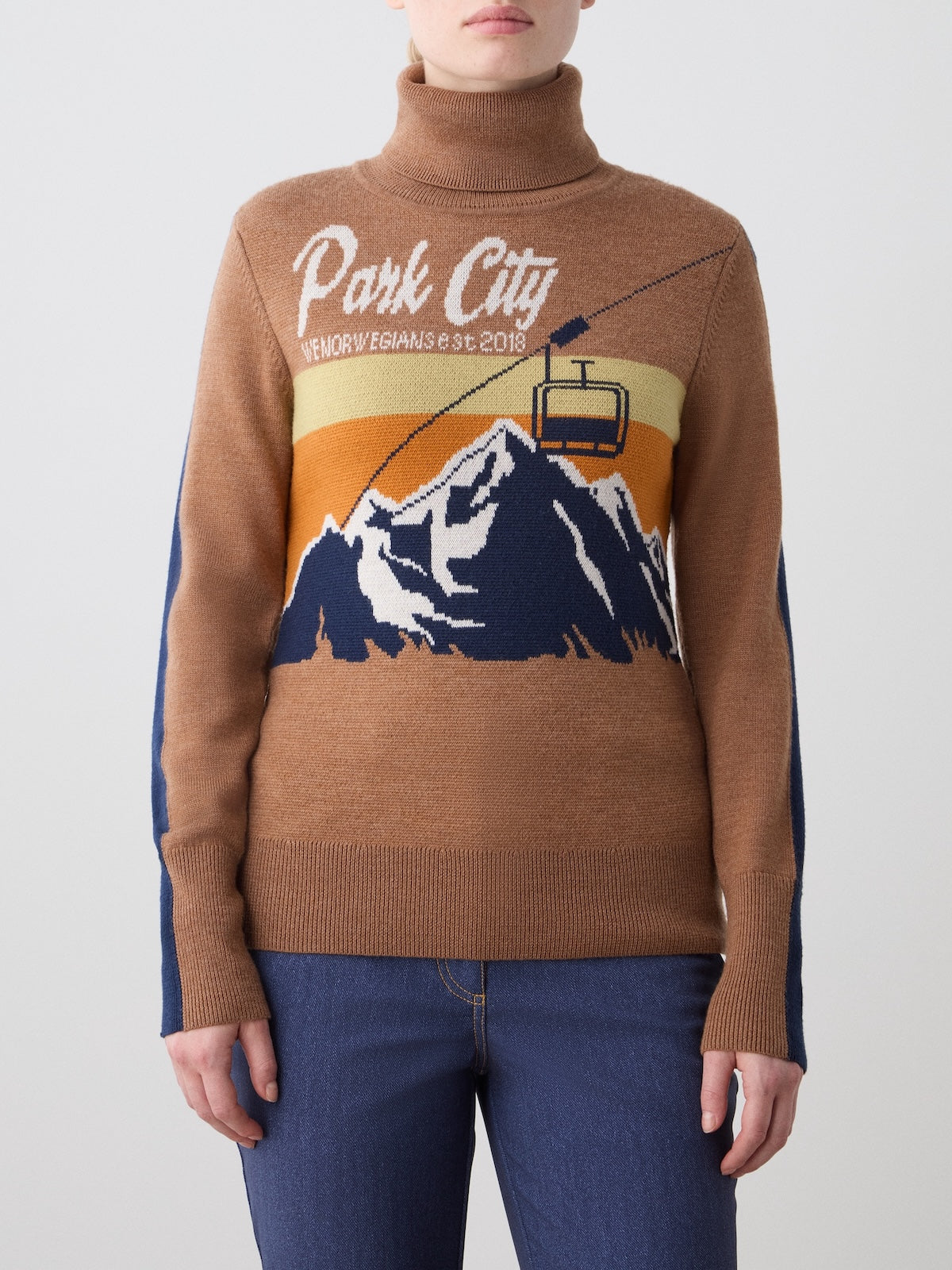 Front view of brown AfterSki Sweater showcasing mountain and gondola jacquard artwork on a model against a light background
