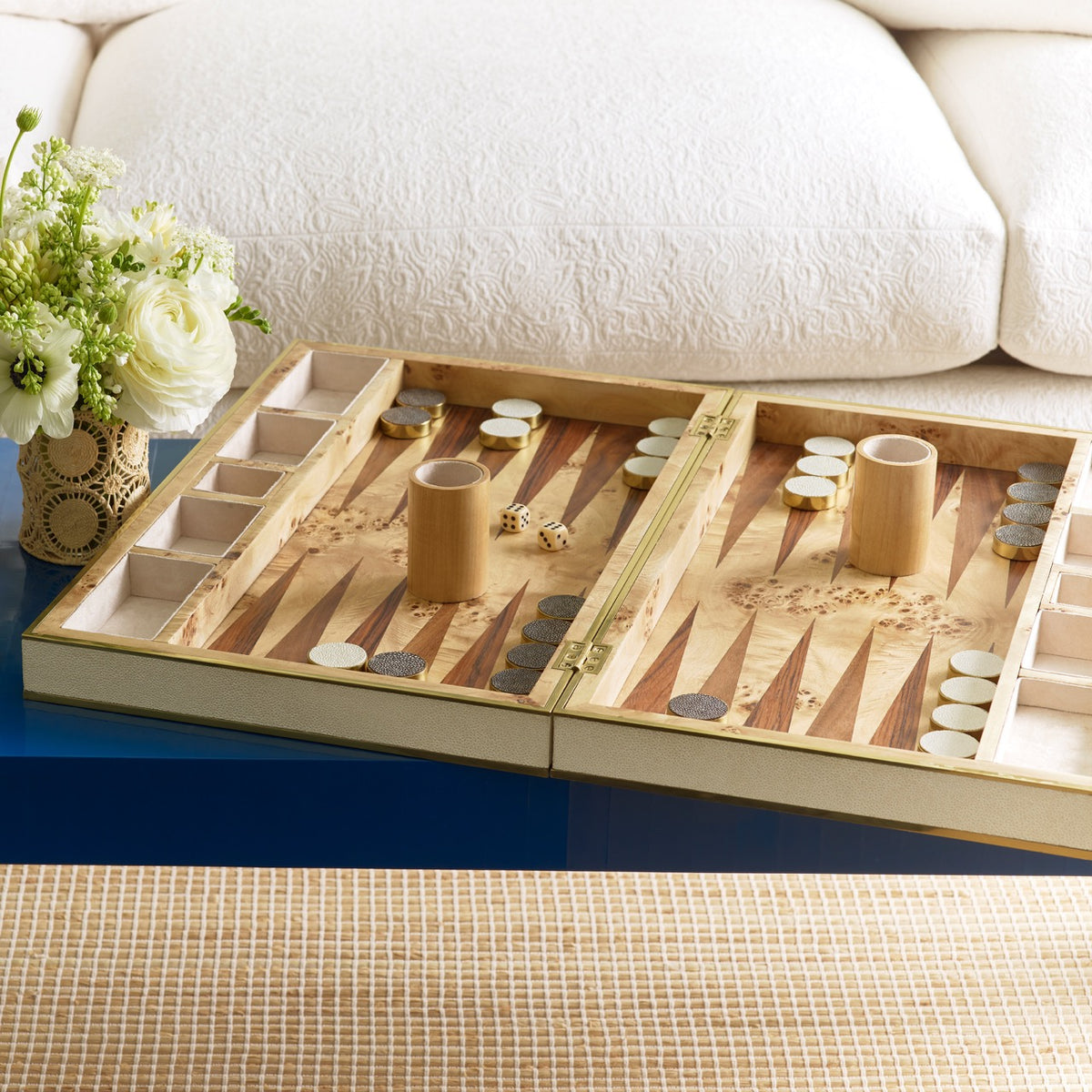 Open view of Cream Shagreen backgammon set showcasing inlaid burlwood surface, brass hinge, dice and chips on blue table