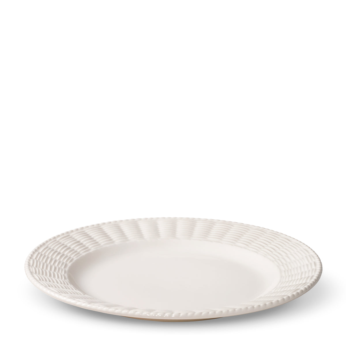 Angled view of Leta Dinner Plate showcasing its white ceramic finish and rattan inspired textured trim with a white background
