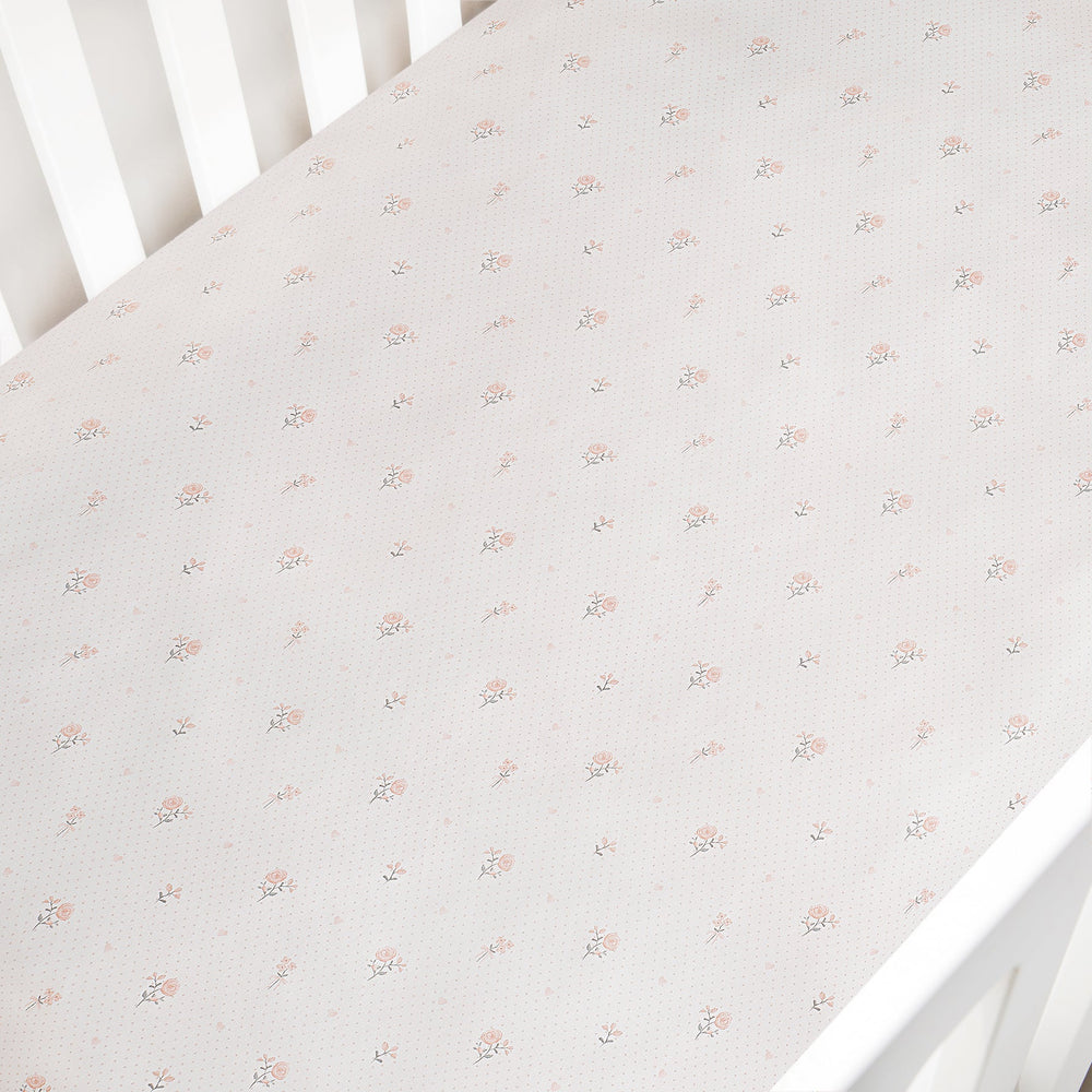 Floral patterned crib sheet on a white crib