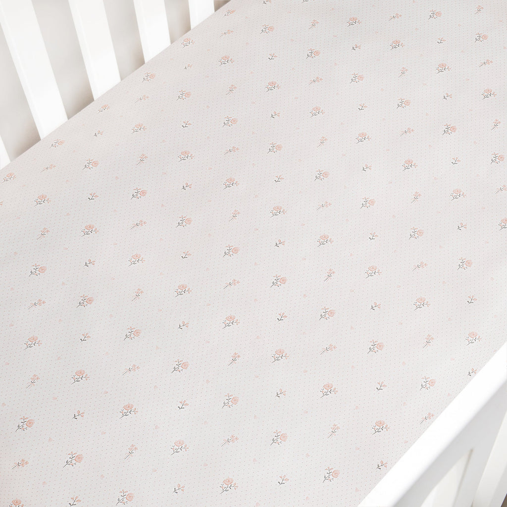Floral patterned crib sheet on a white crib