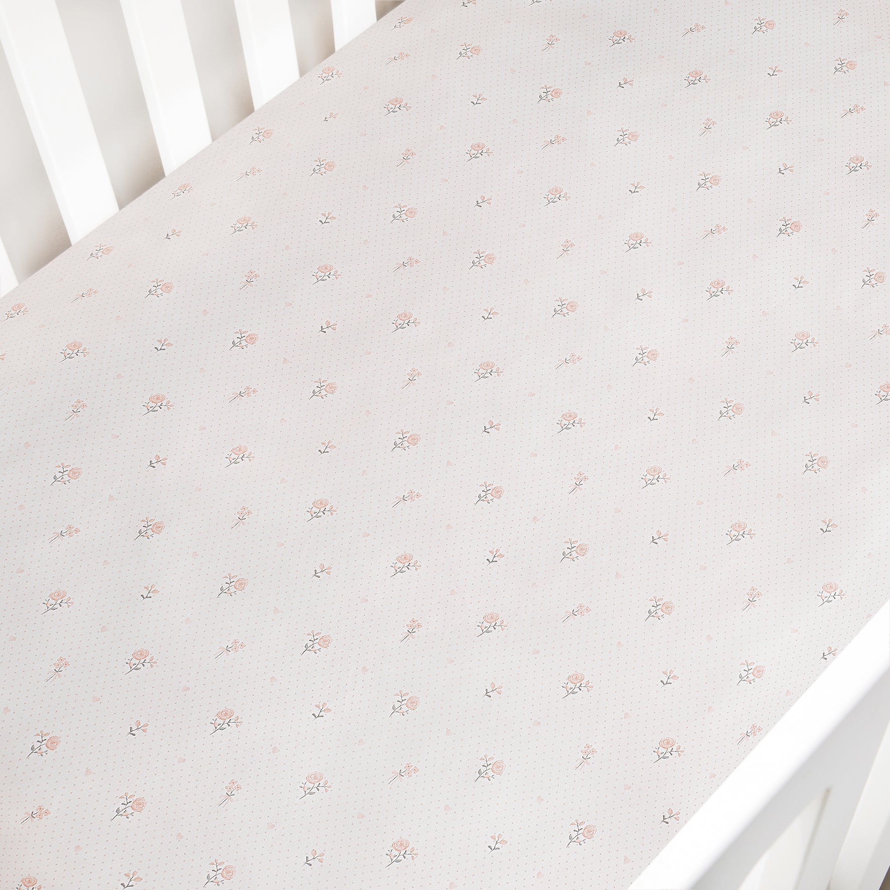 Floral patterned crib sheet on a white crib