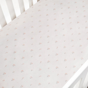 Floral patterned crib sheet on a white crib
