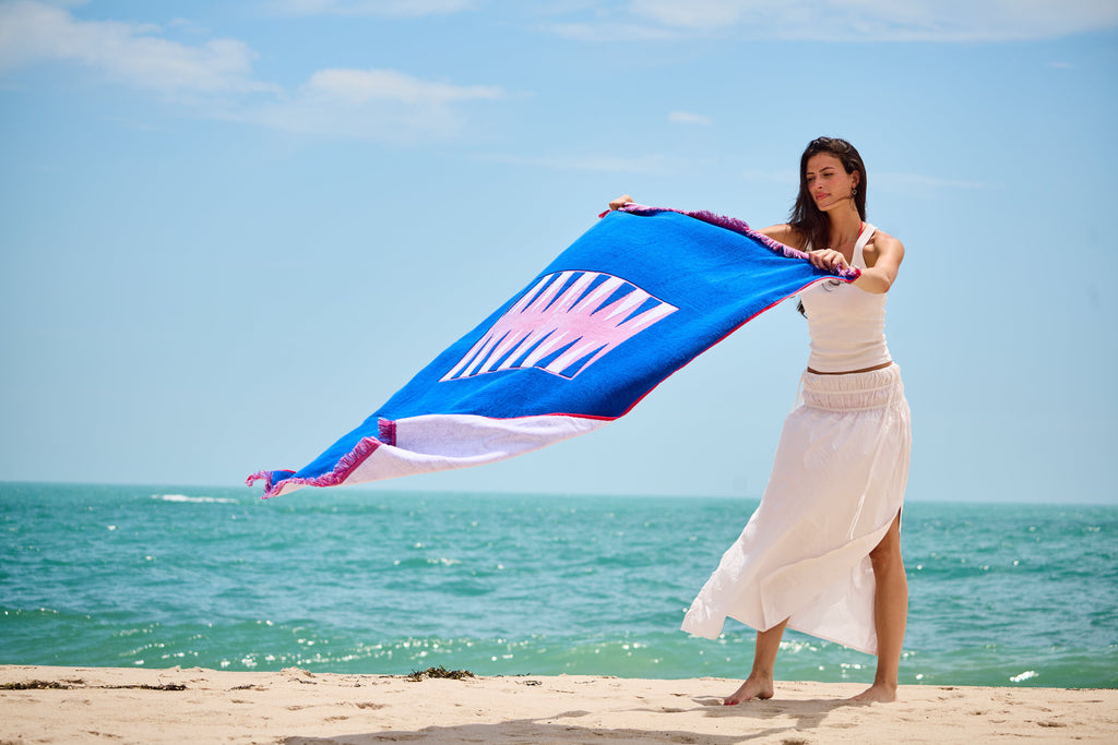 Woman at the beach on a sunny day laying out the Beach Board - blowing in the wind