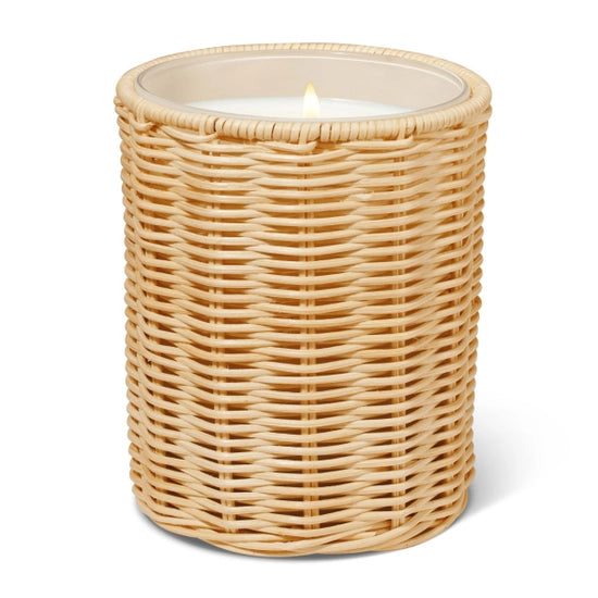 Front view of Freya Candle Sleeve in Natural showcasing handcrafted close weave rattan around a lit candle with a white background
