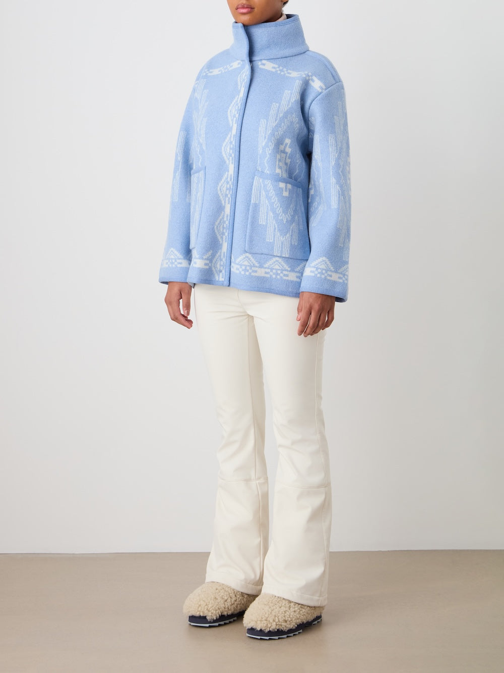 Three-quarter view of Pioneer Jacket in light blue with funnel collar, patch pockets and white pattern on neutral background