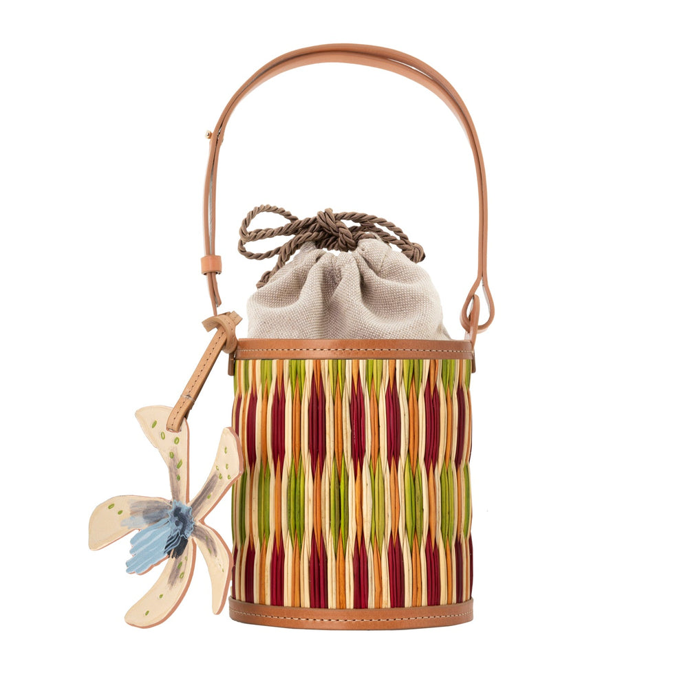 Front view of Cupid Madras bucket bag showcasing multicolor handwoven reed body, leather trim, adjustable strap and drawstring pouch on white background