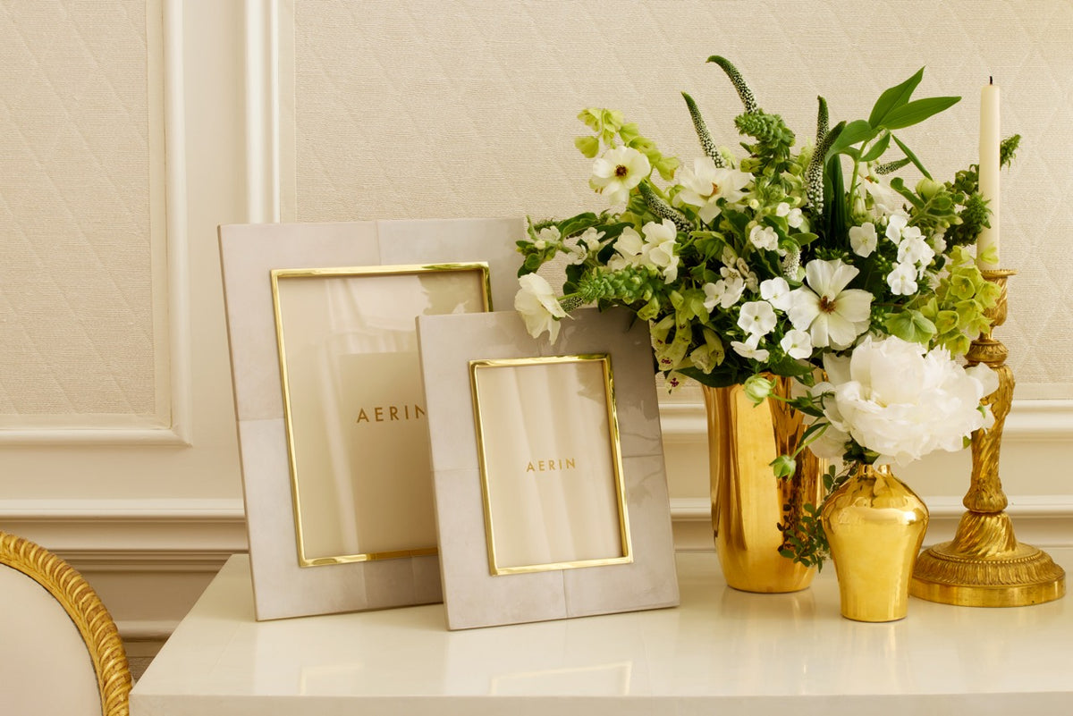 Front view of Livio Parchment 5x7 frame with parchment leather panels and brass trim on cream table