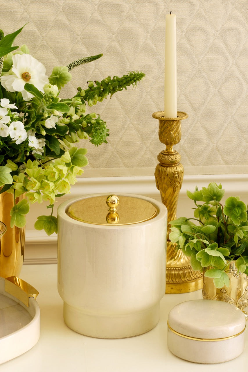 Livio Parchment Ice Bucket with high-shine lacquer and brass lid on styled tabletop with green florals and gold candlestick