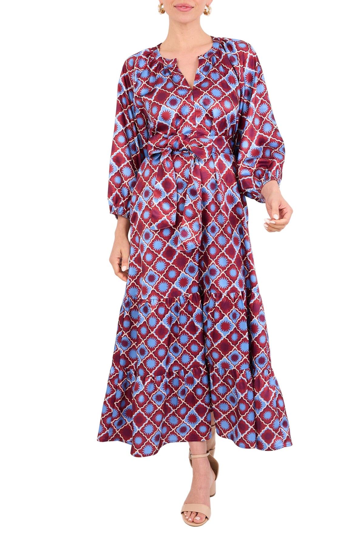 Front view of Elise Dress in Burgundy Sunburst Satin showcasing tiered skirt, sash belt, and three-quarter sleeves on white
