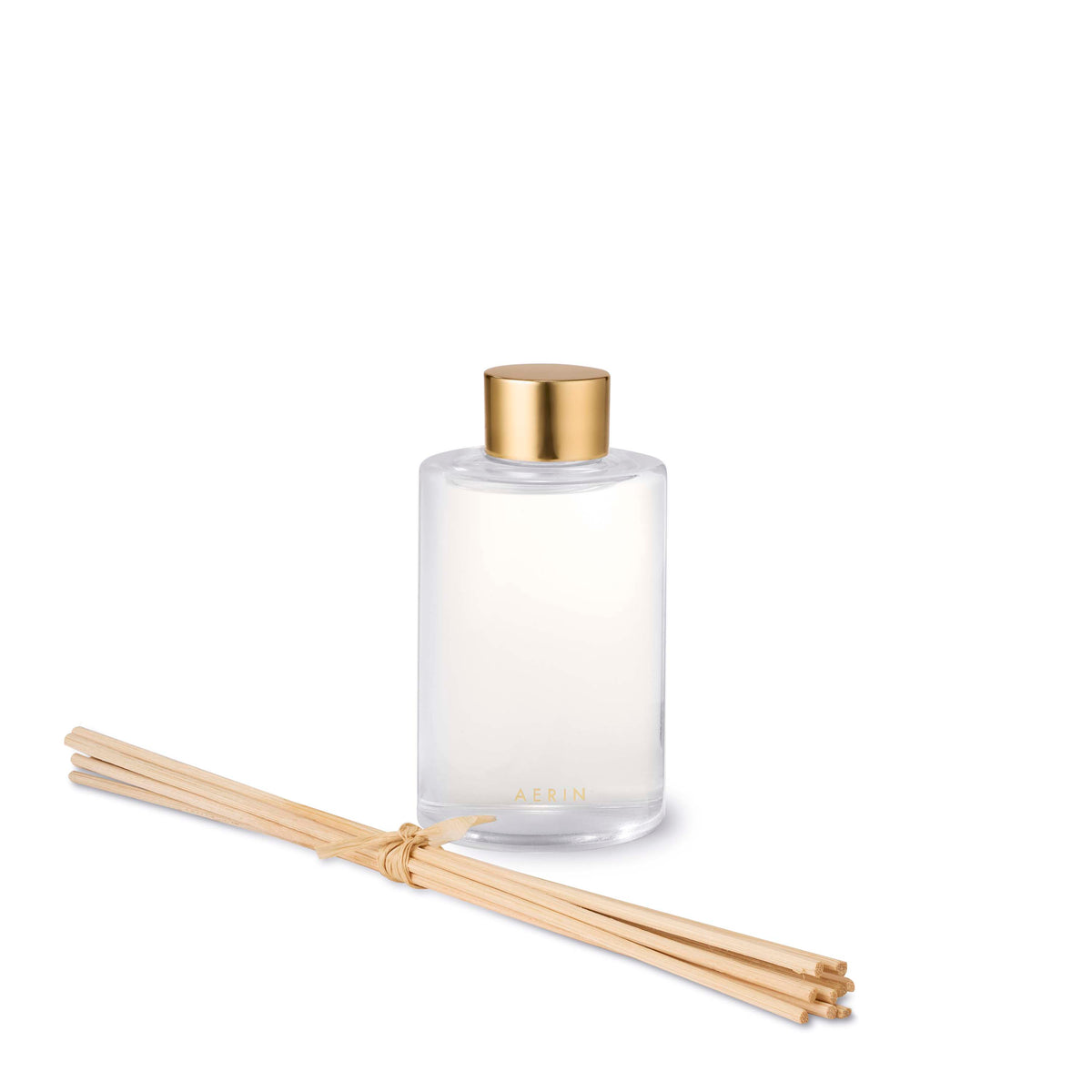 Front view of AERIN Megeve Rose diffuser refill bottle with gold cap and bundled reed sticks on white background