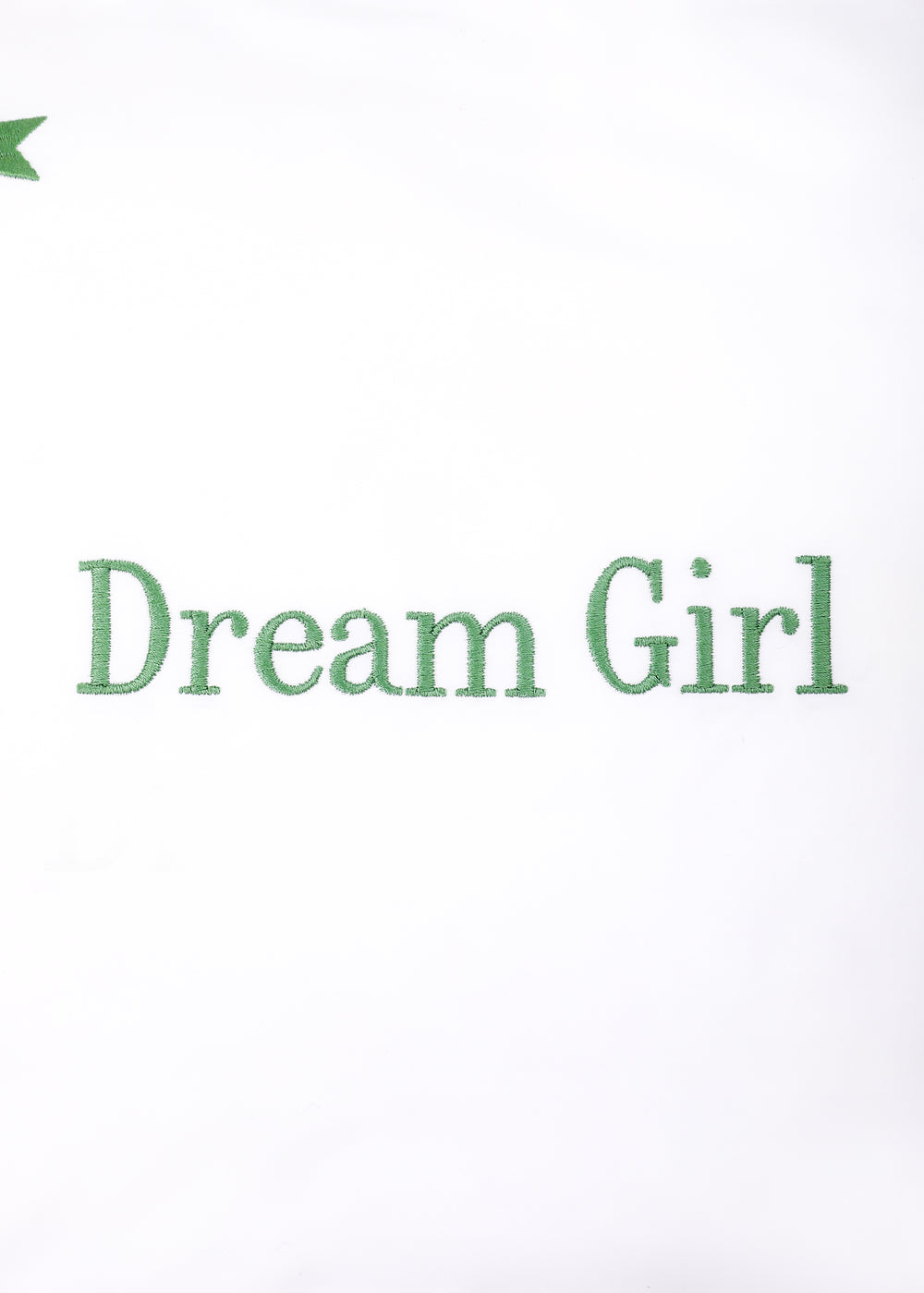 Close-up front of Dream Girl Stars mini pillow showing green Dream Girl embroidery and a small green star on white background