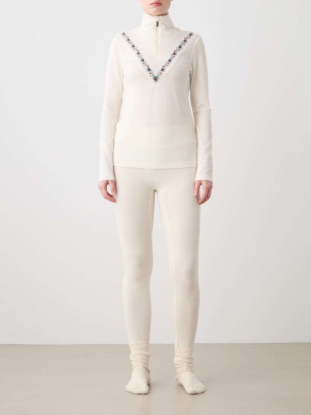 Front view of WN x Markarian Zip Up in Cream showcasing a close fit and embroidered chevron and floral motifs on a light background