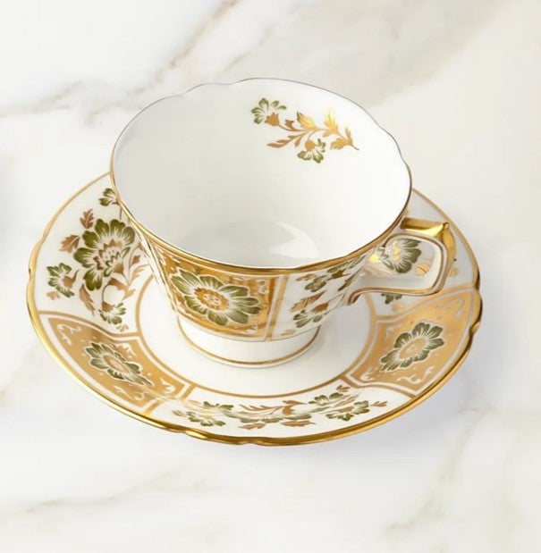 Front view of Derby Panel tea cup and saucer showing green panel flowers and gold trim on white bone china