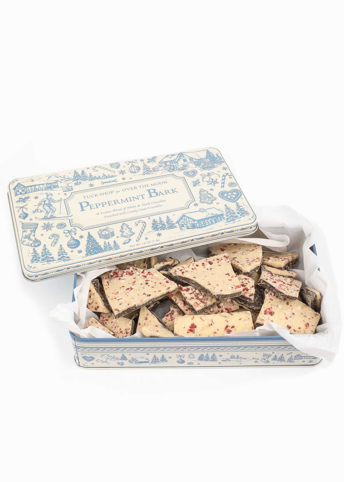 Open view of Tuck Shop for Over The Moon Peppermint Bark showcasing peppermint-topped chocolate pieces in a keepsake tin on a white background