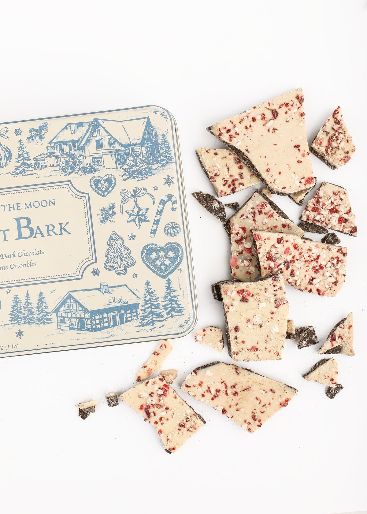 Overhead view of Tuck Shop for Over The Moon Peppermint Bark showcasing peppermint-topped pieces and keepsake tin