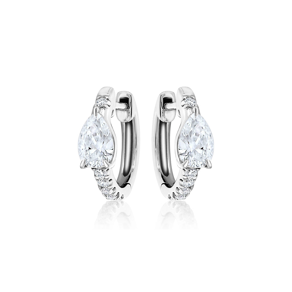 The Pavé Huggie with Pear Diamonds earrings showcase a large teardrop-shaped clear gemstone and smaller round stones on the front, beautifully displayed on a white background.