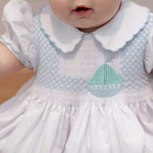 Henry Duvall Eloise Bubble in white cotton with Bailey’s Bay Blue trim and hand-smocked sailboats, classic heirloom baby girl summer outfit with scalloped Peter Pan collar