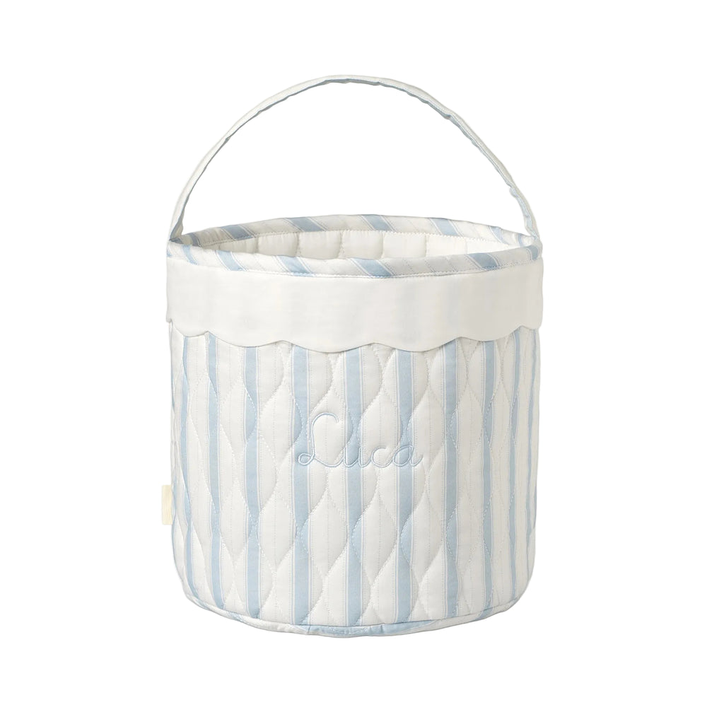 Blue ad white striped quilted basket with handle on while background.