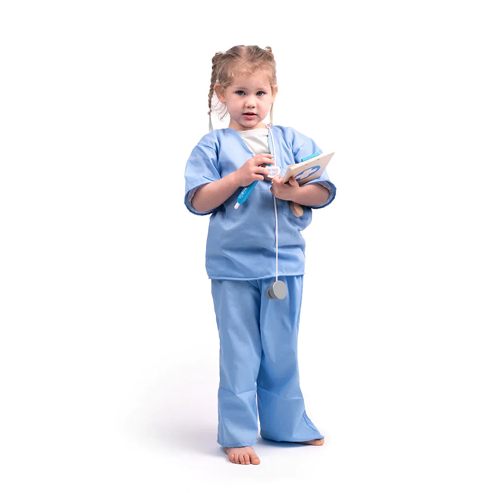 Front view of child wearing blue medic dress up showing scrub top and trousers with toy stethoscope, clipboard and thermometer on white background