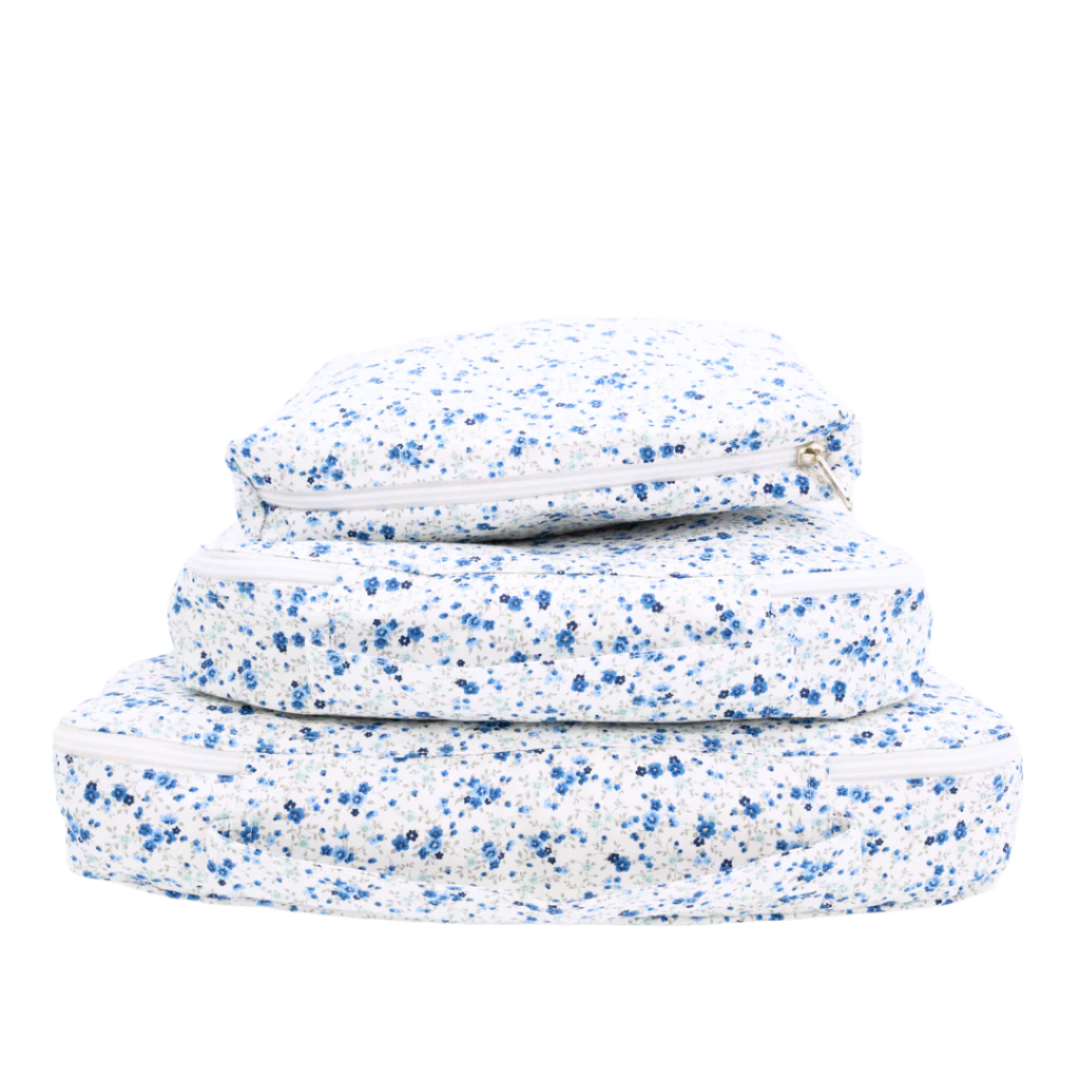 Stacked view of Emmie Packing Cubes showcasing assorted sizes and blue floral print with a white background