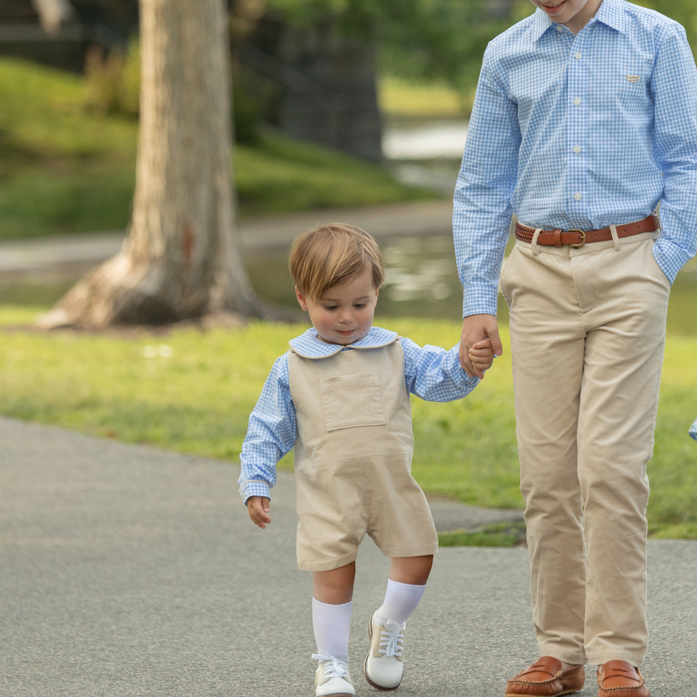 Front view of Oliver Overalls in King’s Way Khaki corduroy with adjustable straps, relaxed fit, layered over blue Peter Pan shirt