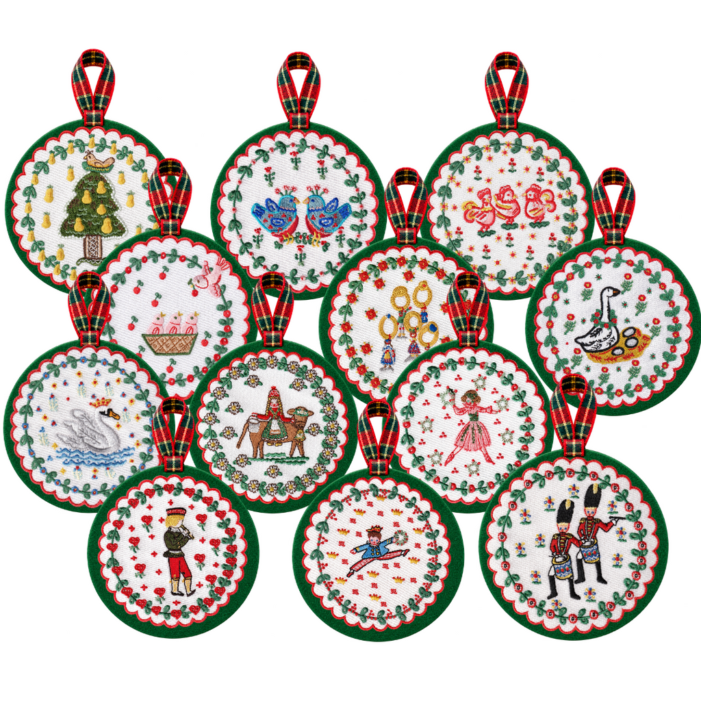 A set of 12 round embroidered Christmas ornaments with red and green plaid hanging tabs, displayed on a plain white background.
