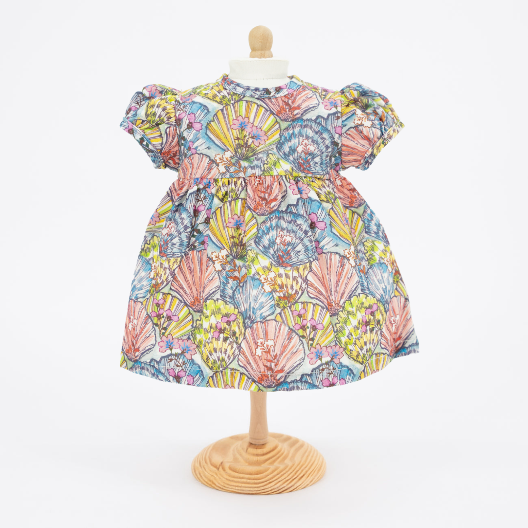 Front view of Shelly Doll Dress showcasing short sleeves and colorful floral fan print on a wooden mannequin