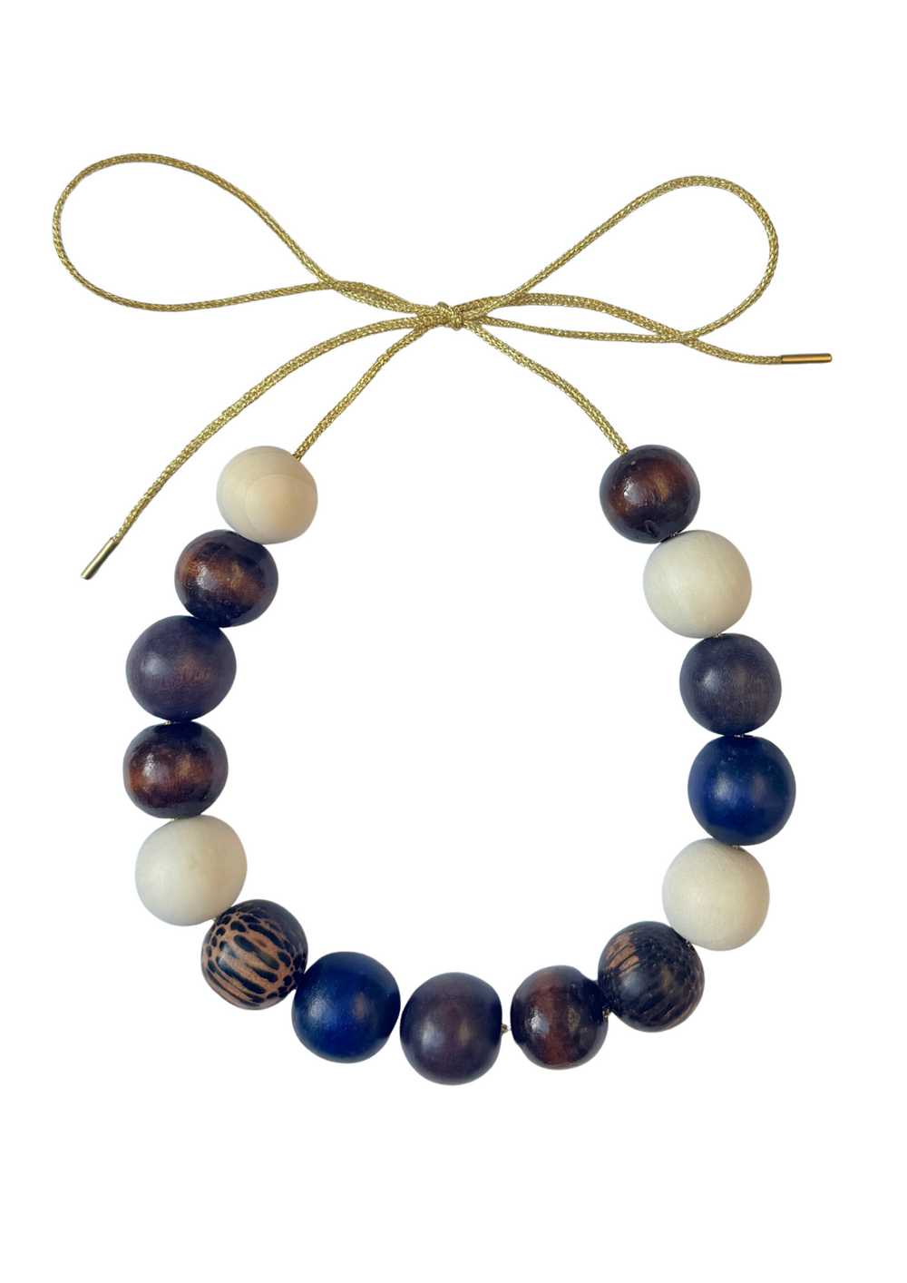 Front view of Courchevel Bubble Necklace with mixed wood and painted beads on a gold lurex cord tied in a bow on white