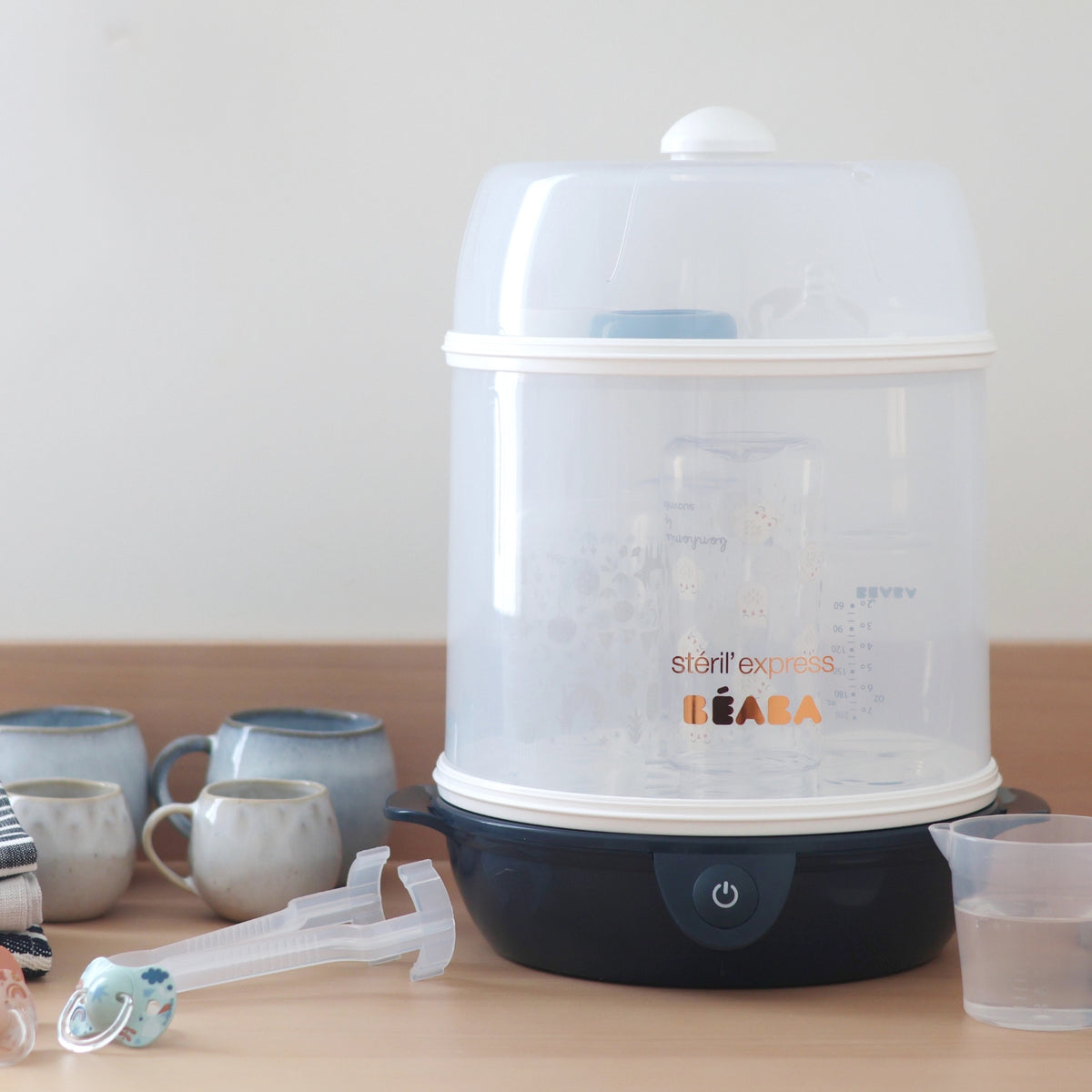 Front view of Steril Express 2-in-1 Bottle Sterilizer in Midnight with clear chamber, dark base and power button on tabletop