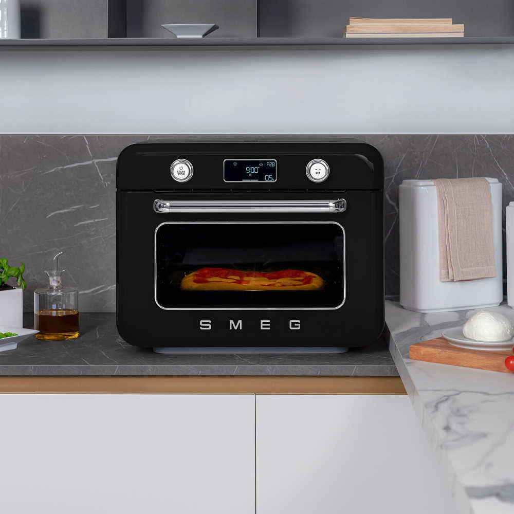 Front view of Smeg Combi oven showing pizza through glass door, digital display and chrome handle on marble counter
