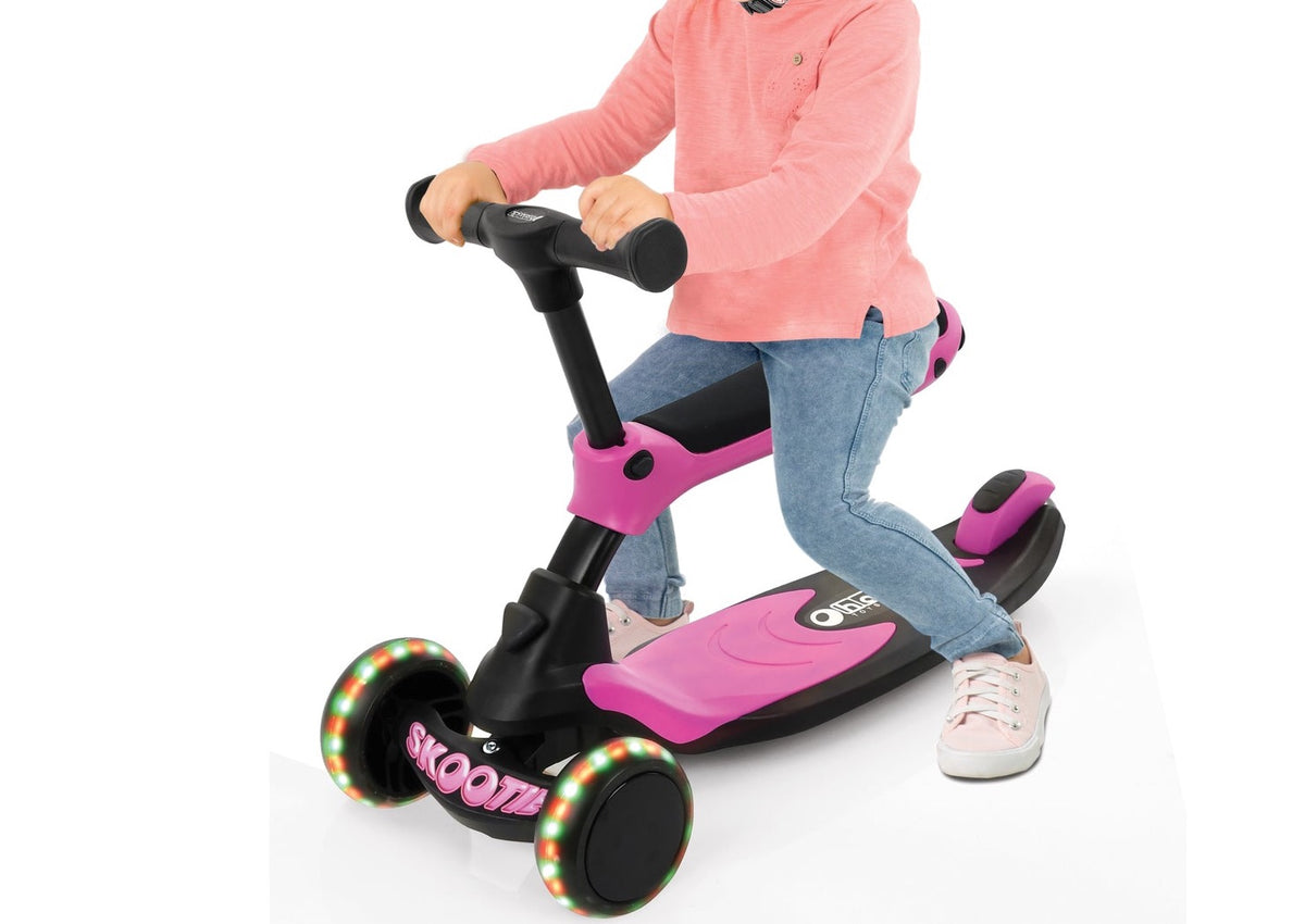 Side view of Hauck Skootie 2-in-1 in neon pink, showing a child riding the three-wheel scooter on a white background