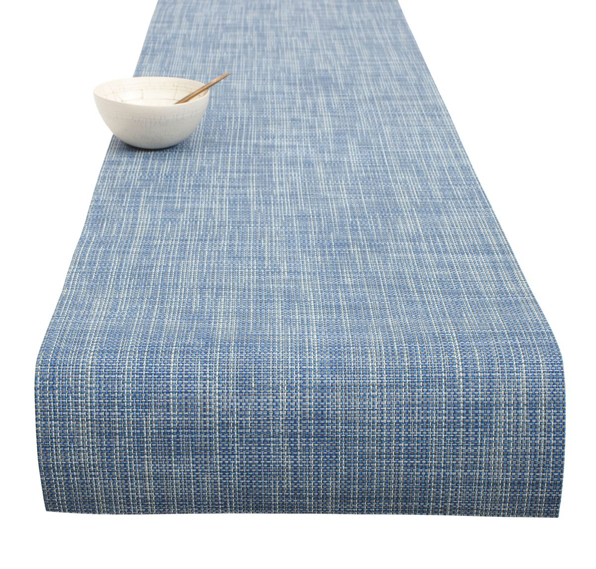 Angled view of Mini Basketweave Table Runner showcasing blue woven texture with a white bowl and spoon