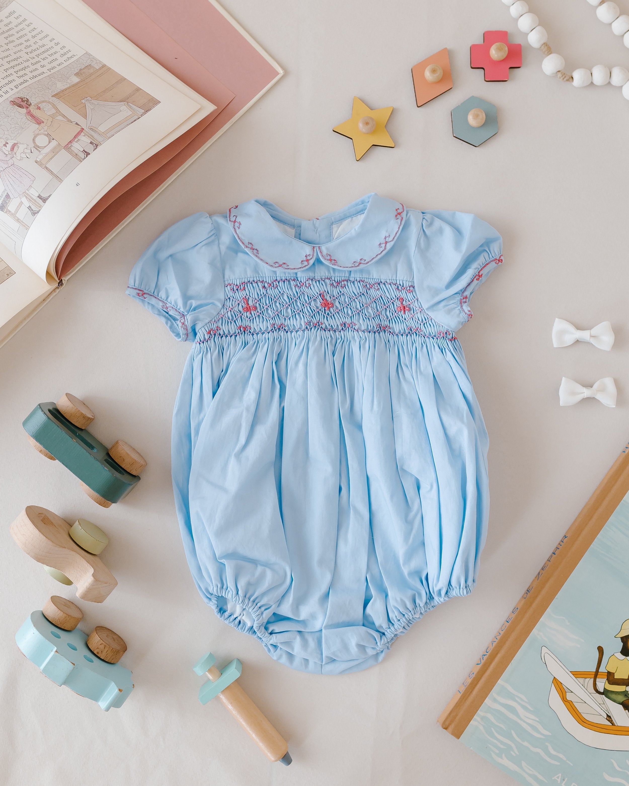 シャーロットドレス ロンパース Princess Charlotte Sky Blue Smocked Baby Romper | Over The Moon