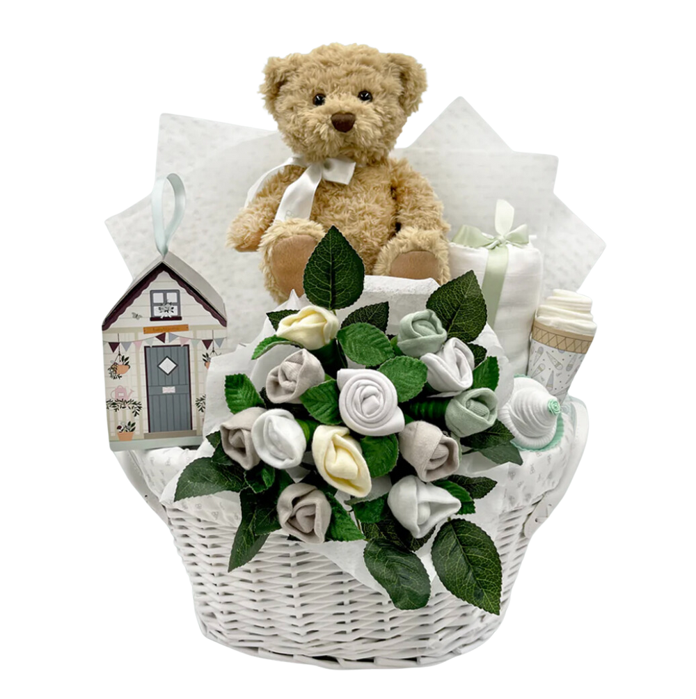 Front view of Berties New Baby Gift Basket showcasing a teddy bear and baby clothes bouquet in a white woven basket