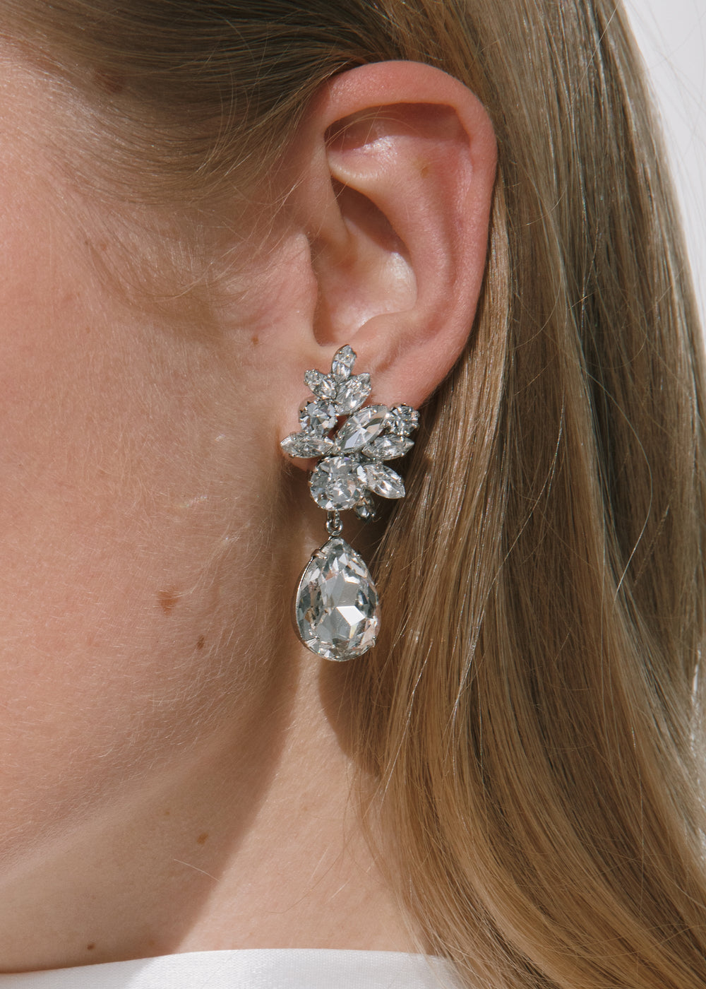Close-up of Lynlee crystal earrings on model showing clustered Czech crystals and pear-shaped dangling drop