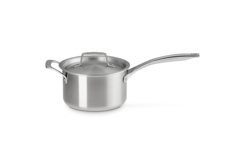 Front-right view of Le Creuset Essential Stainless Steel 3 qt saucepan with lid, brushed finish and long handle on white background