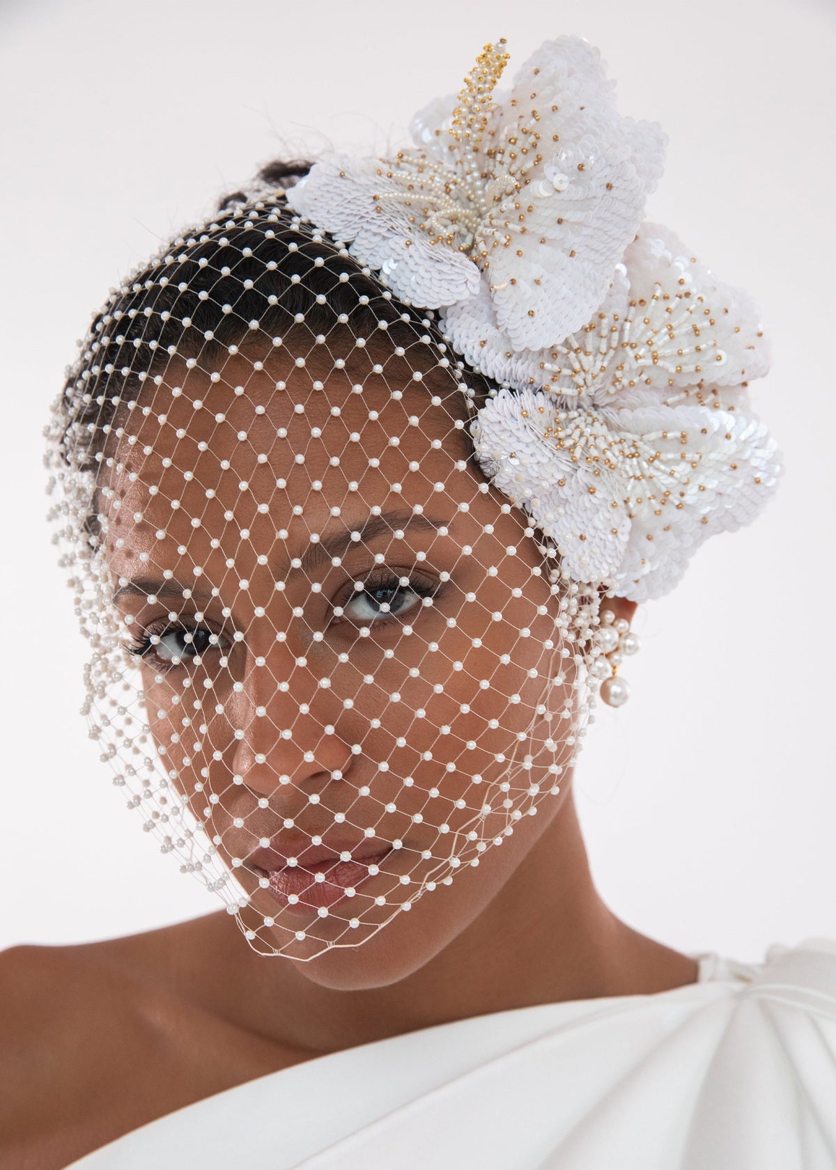 Front view of Crystal Orchid Voilette in Cream showcasing pearl veil and beaded orchid flowers on a model
