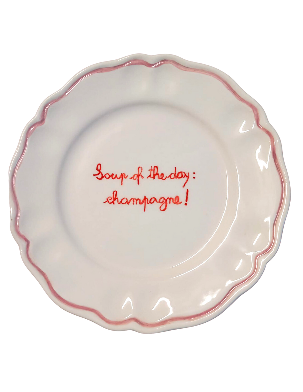 Top view of Champagne scalloped plate showing pink rim and red handwritten Soup of the day: champagne on white background