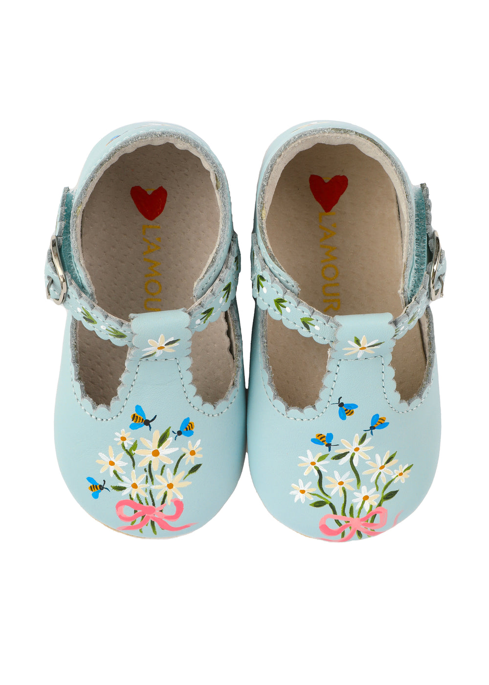 Top view of blue scalloped baby shoes showcasing hand-painted daisy bouquet and bees with scalloped buckle strap on white background