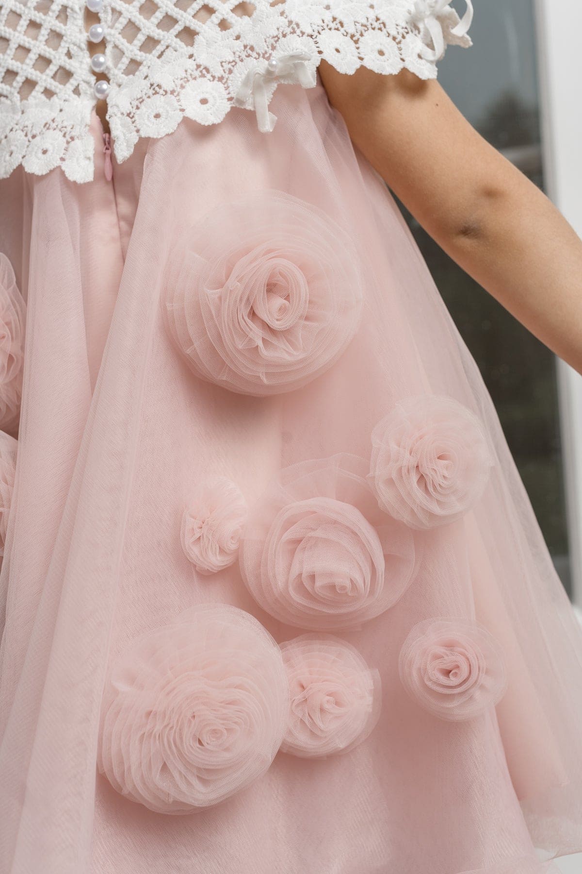 Close up of girls pink tulle dress with 3D flower details