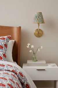 Hand-marbled clip-on sconce shade mounted on wall above bedside table