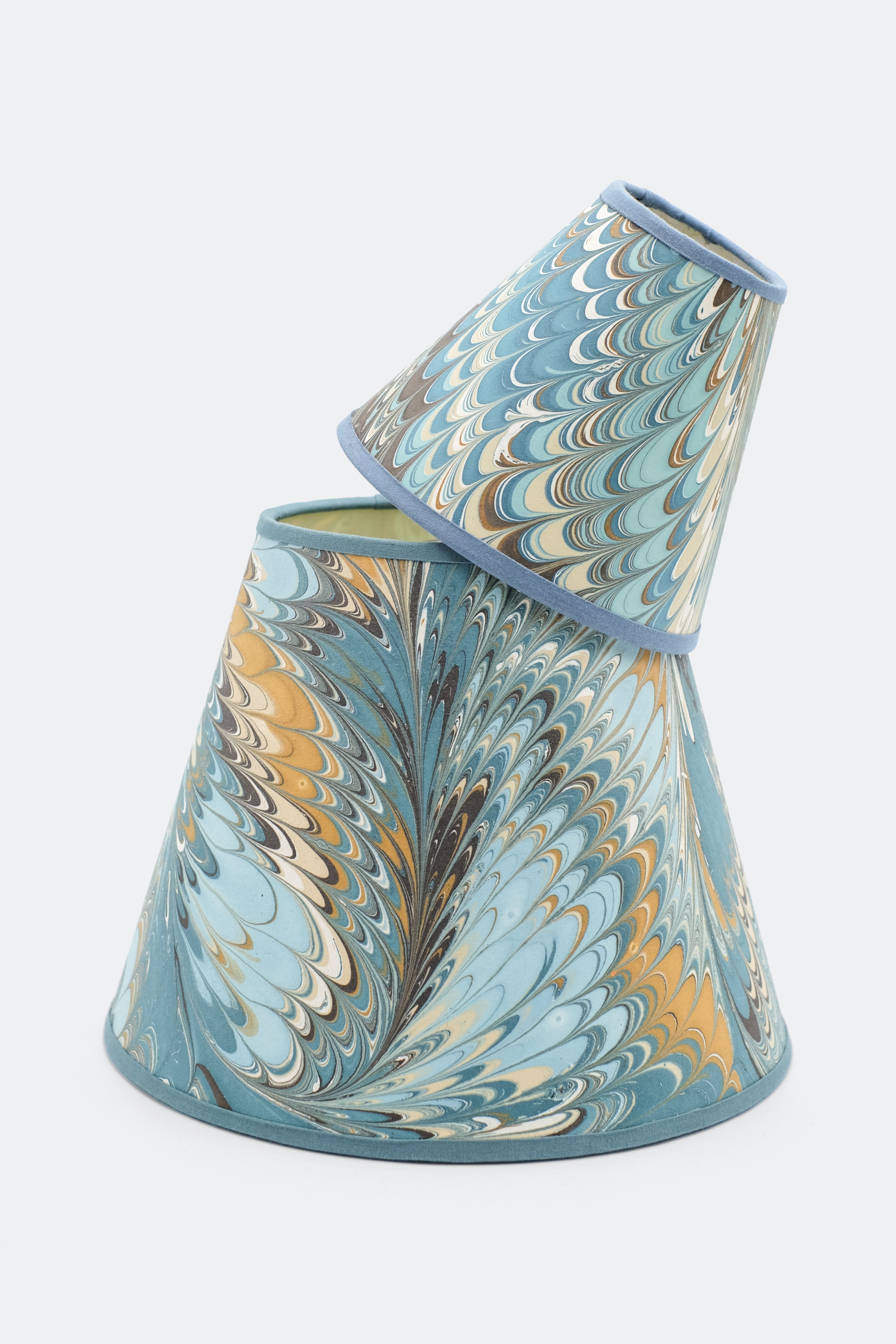 Nila Feathers hand-marbled clip-on lampshades stacked for display