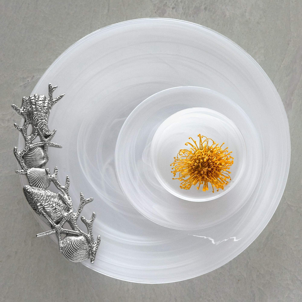 Top view of White Alabaster Seaside Platter with milky swirls and silver seashell-and-coral handles on gray background
