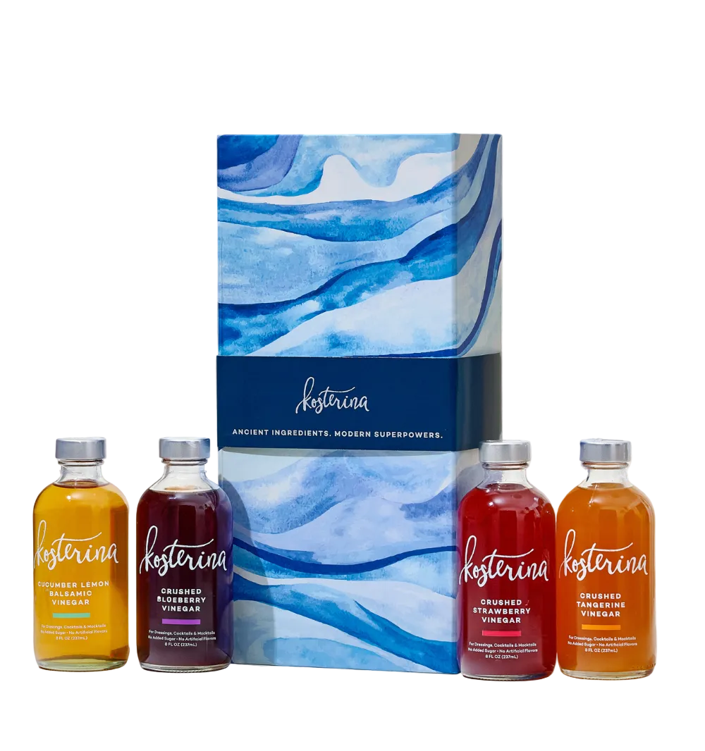 Front view of Kosterina Holiday Cheers Gift Set showing a blue-and-white gift box with four crushed fruit vinegar bottles on a white background