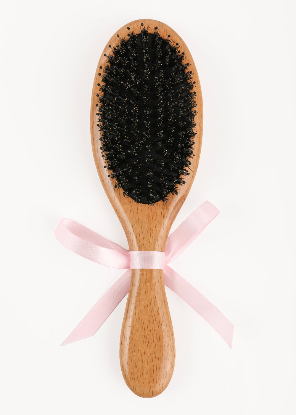 Top-down view of beechwood hairbrush showing black boar-hair and nylon pin bristles with pink ribbon on white background
