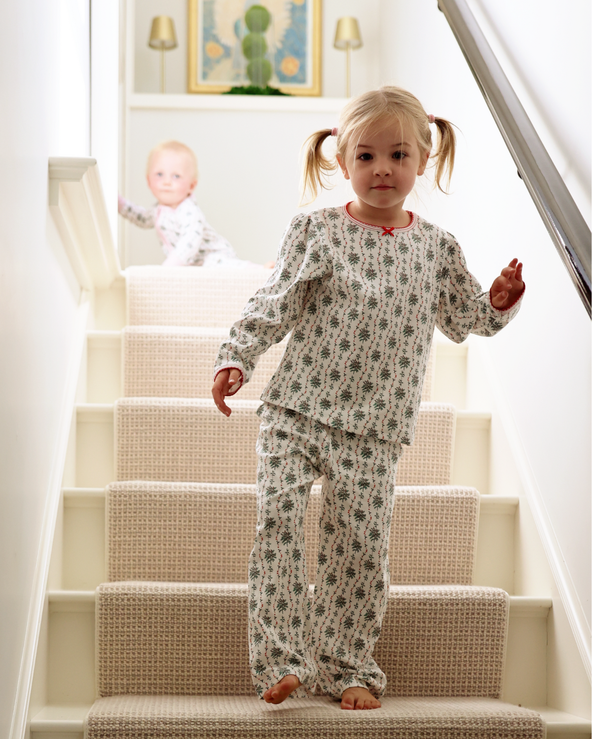 Front view of Holly Long Kids Camp Set Set of 2 with hand drawn greenery and red berry print on child standing on stairs