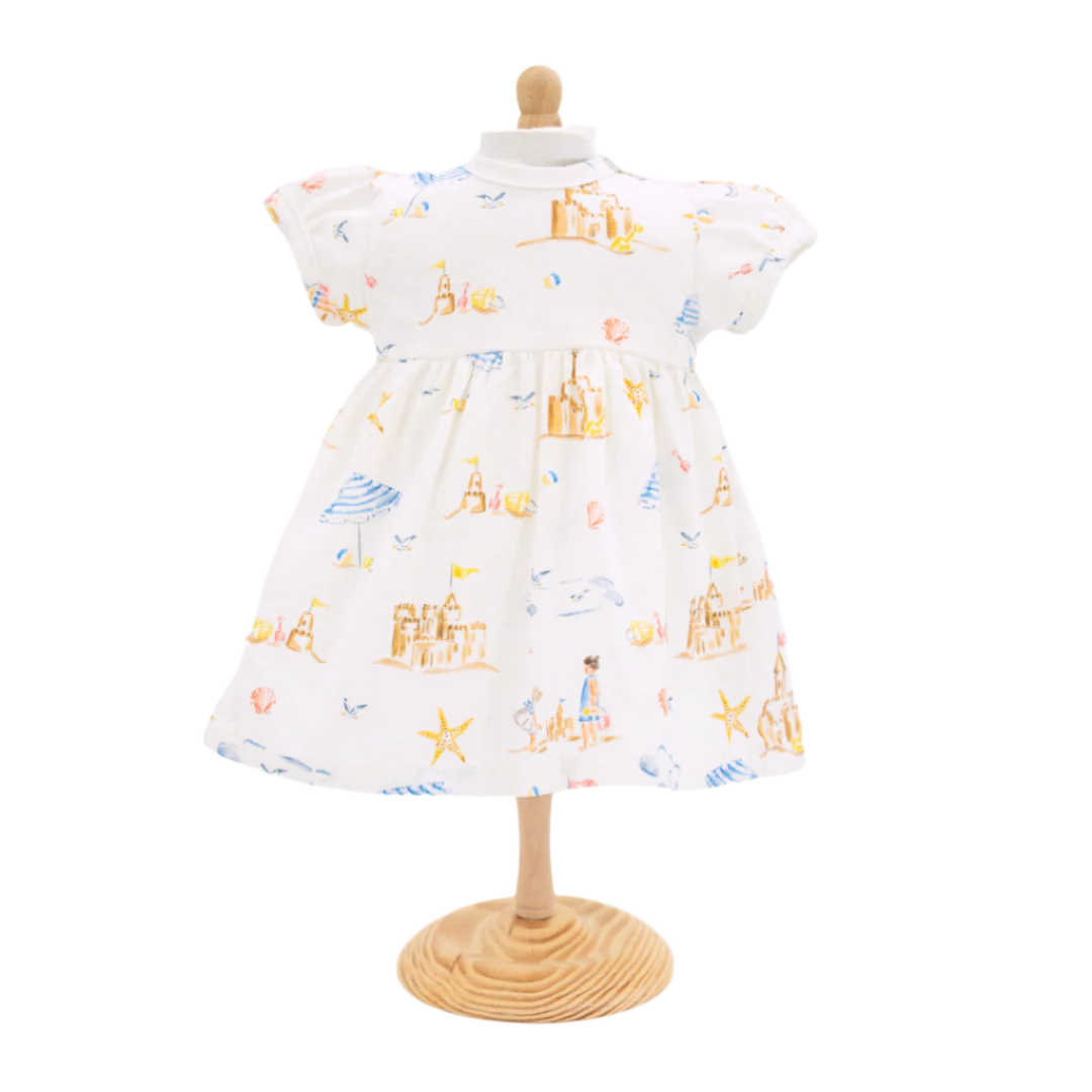 Front view of Sandy Doll Dress showcasing beach-themed watercolor print and puff sleeves on wooden doll stand